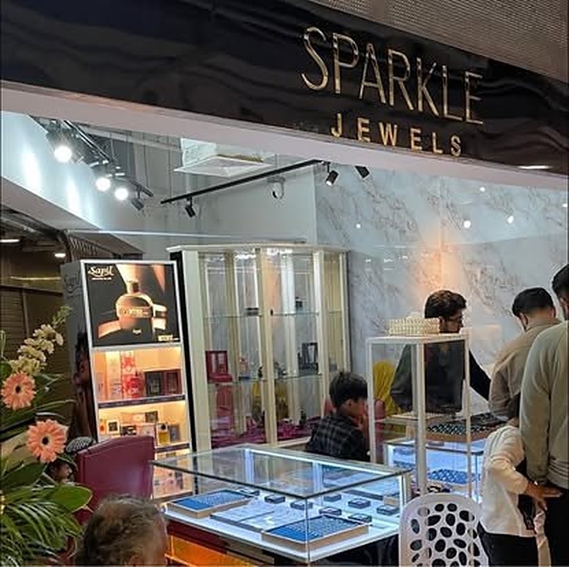 Inside the Sparkle Jewels shop, lit display cabinets and customers at the counter