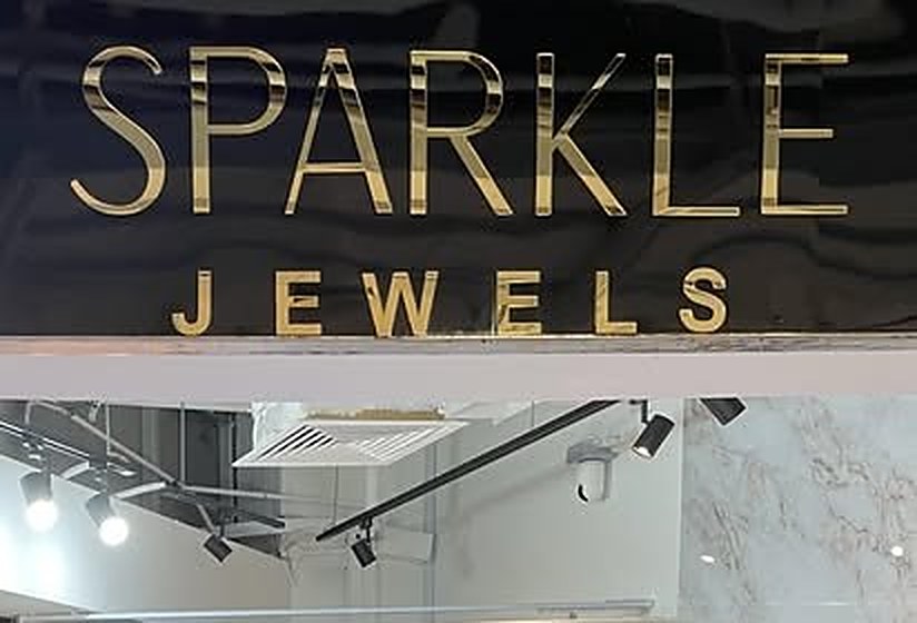 The Sparkle Jewels gold channel letter signage on white marble