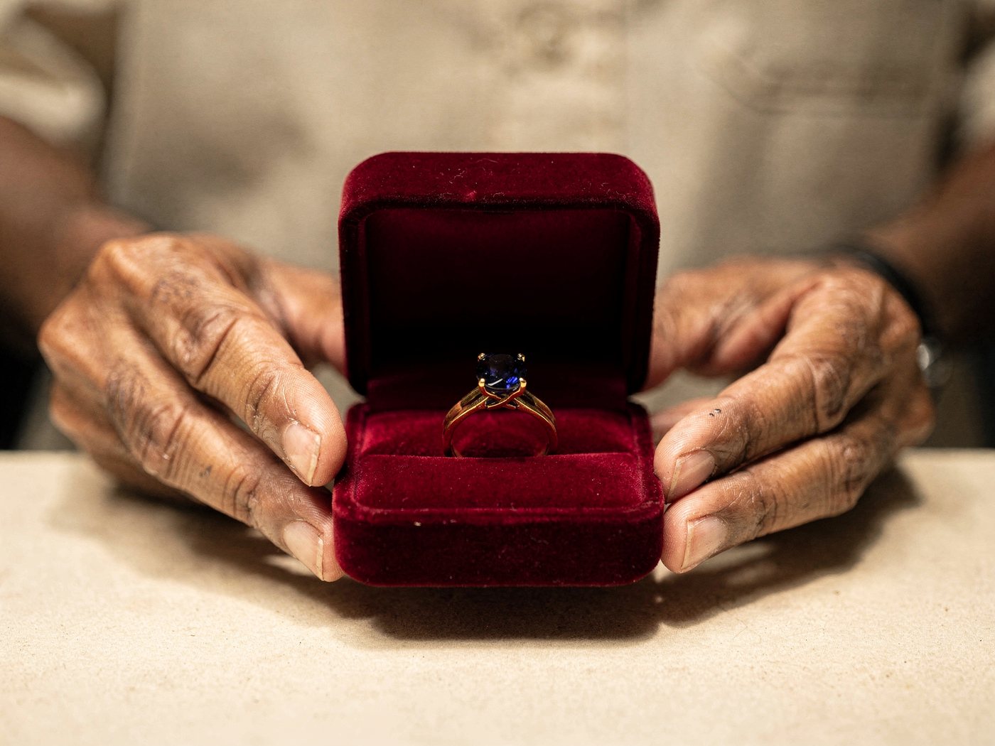 A finished gold and sapphire ring presented in a red velvet box